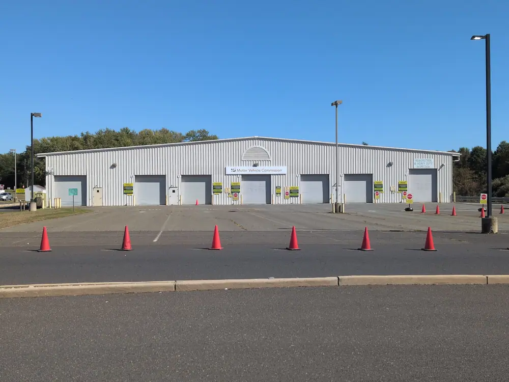 Commercial warehouse building with several garage doors and orange traffic cones in the parking lot